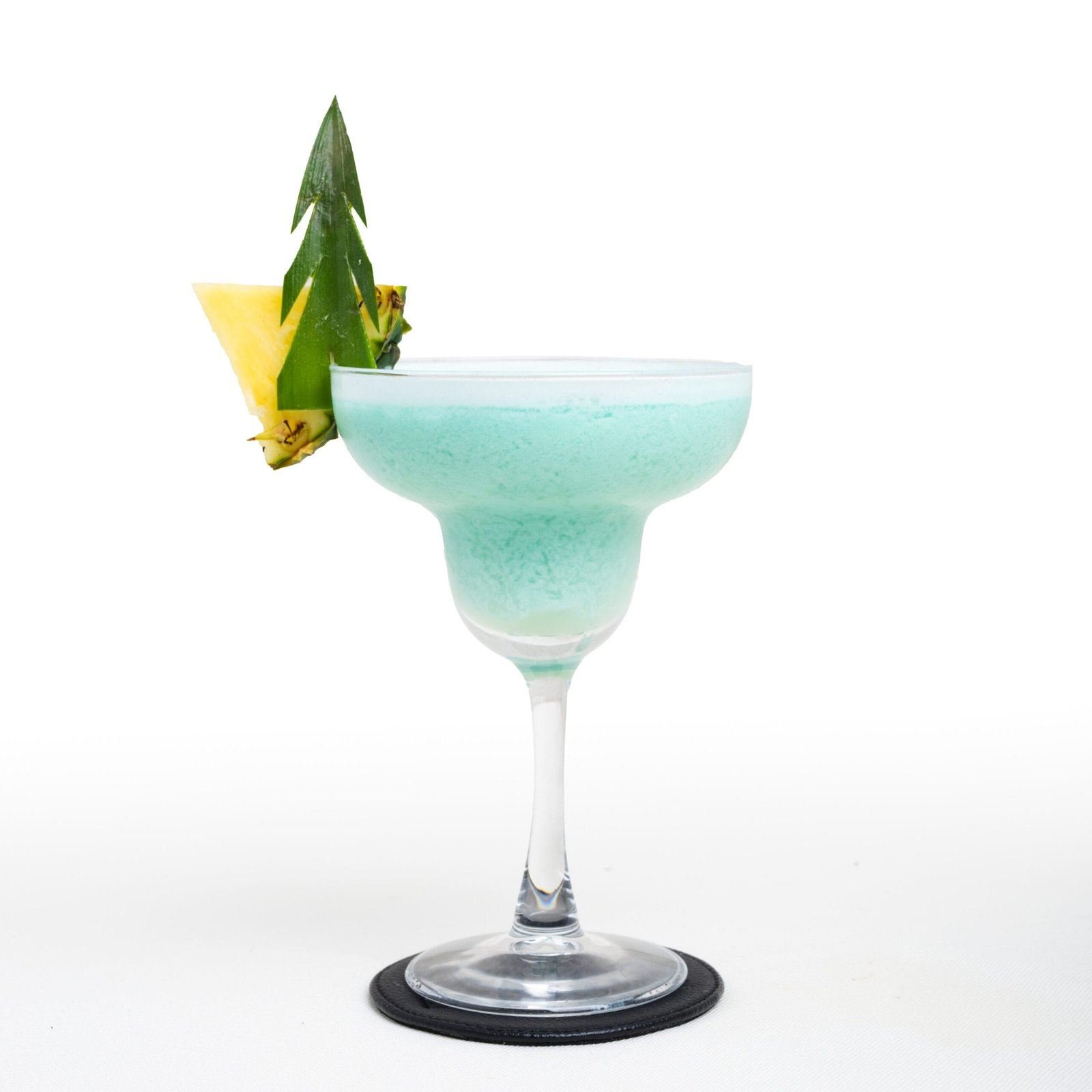 Cocktail bleu glacé décoré d'une feuille d'ananas