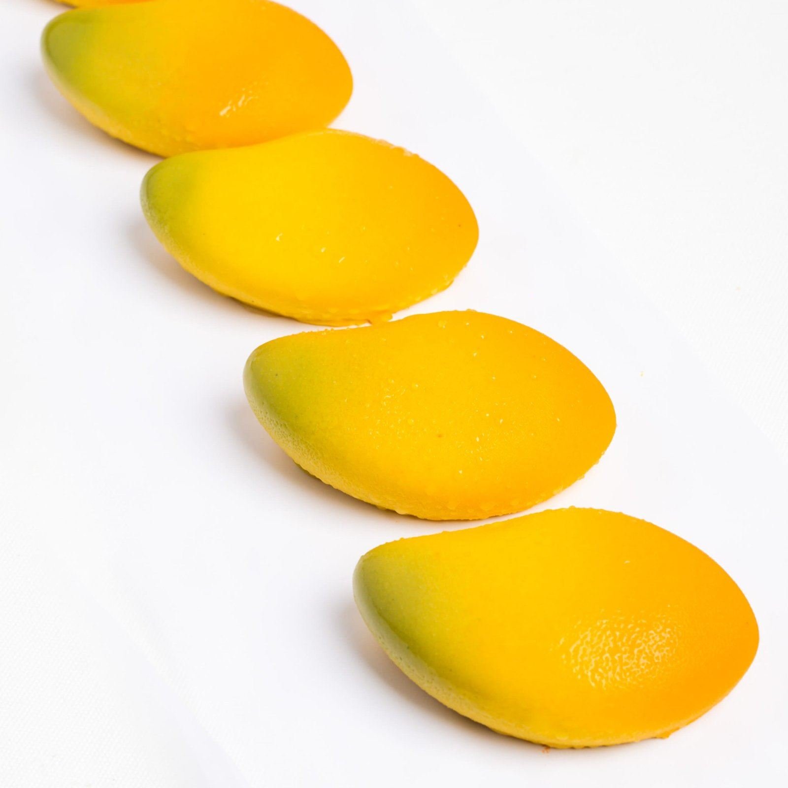 Petits entremets jaune vif en forme de mangue
