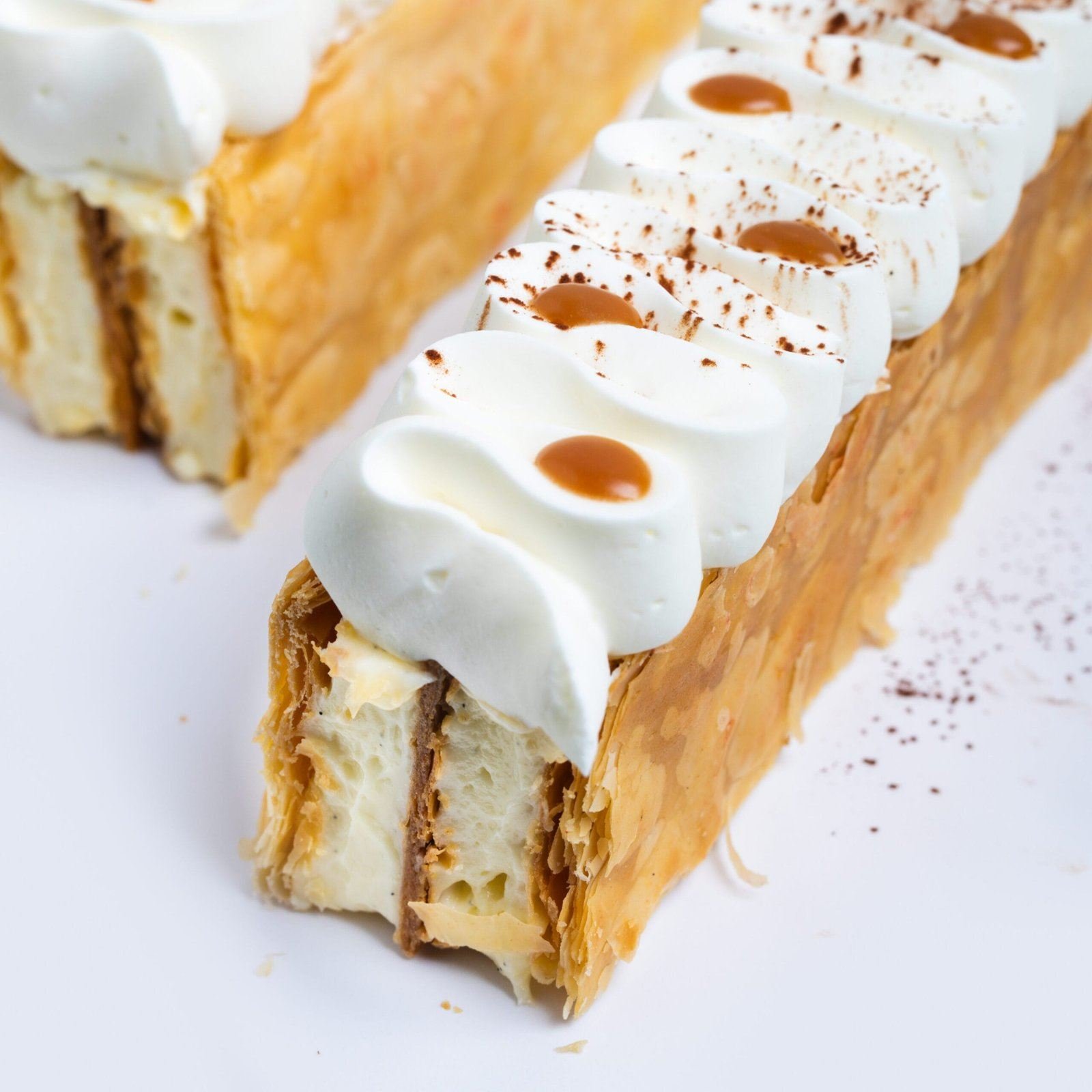 Millefeuille garni de crème en rosaces et de gouttes de caramel