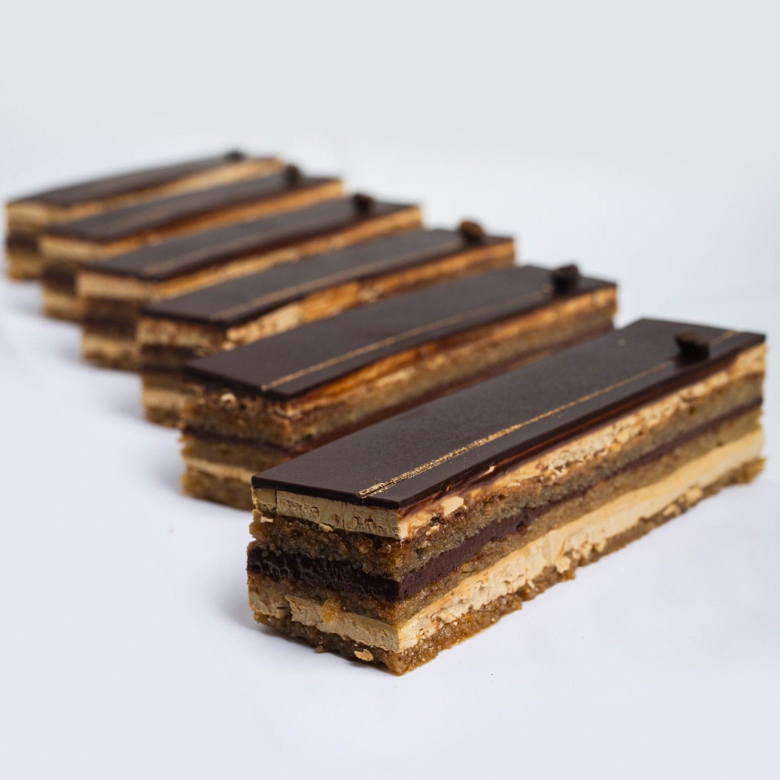 Gâteaux opéra en couches de biscuit, café et glaçage chocolat