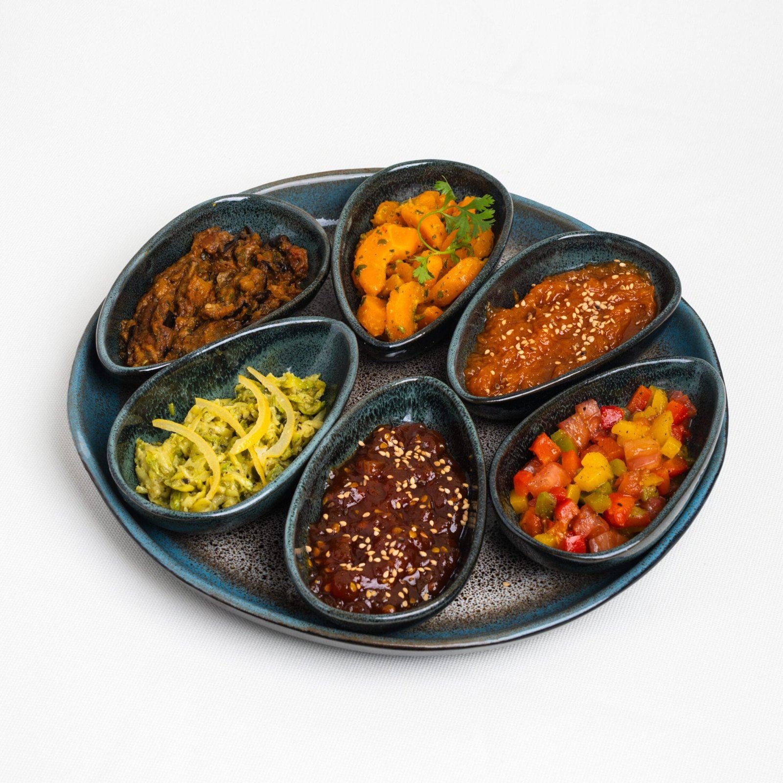 Plateau de six petits compartiments garnis de salades et condiments