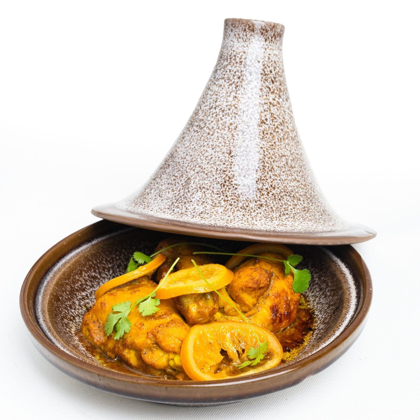 Tajine en terre au couvercle conique, citrons confits et coriandre