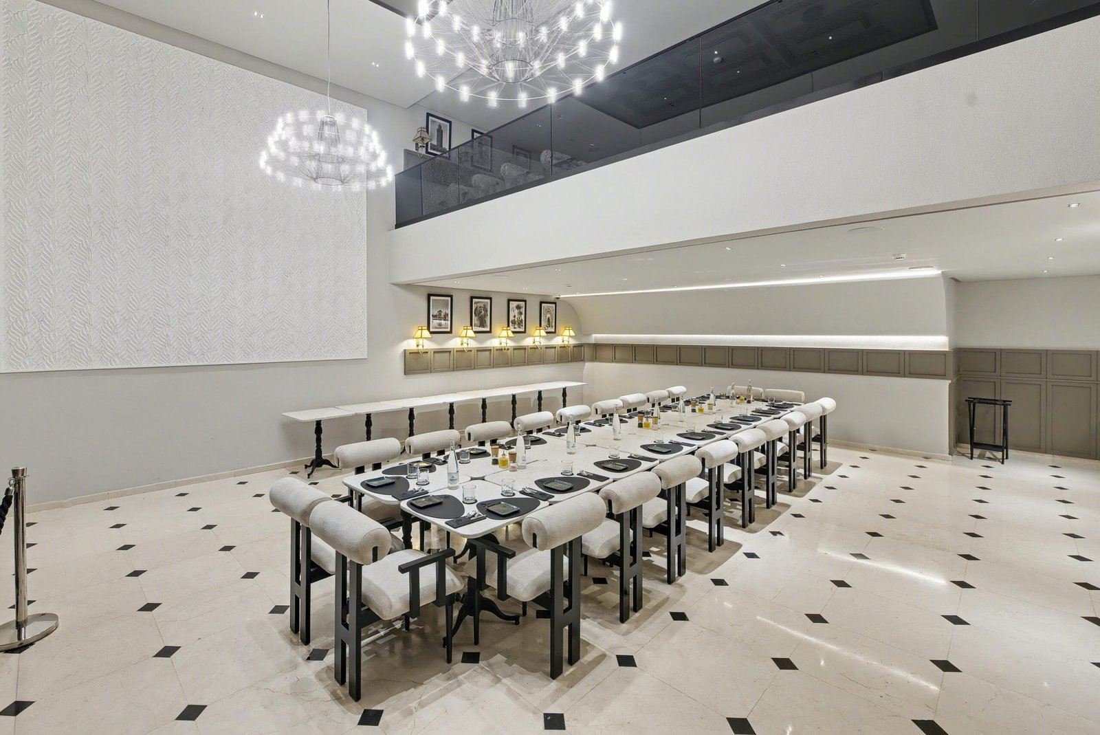 La longue table de la salle, dressée avant le service, sous les lustres