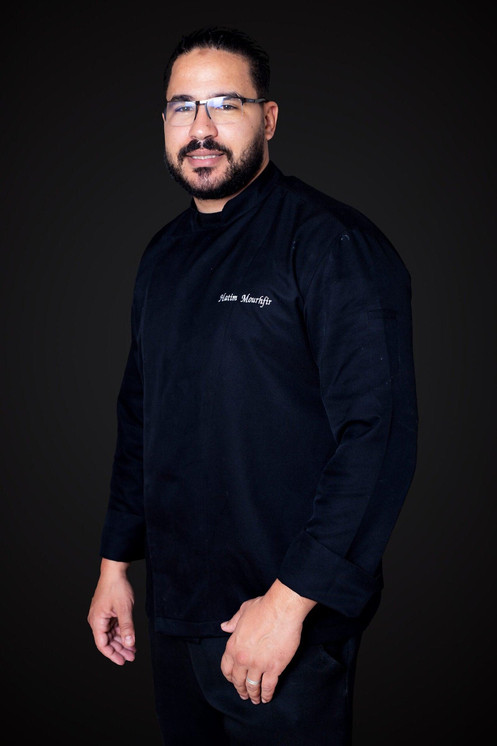 Portrait d'un chef en veste noire, de trois quarts