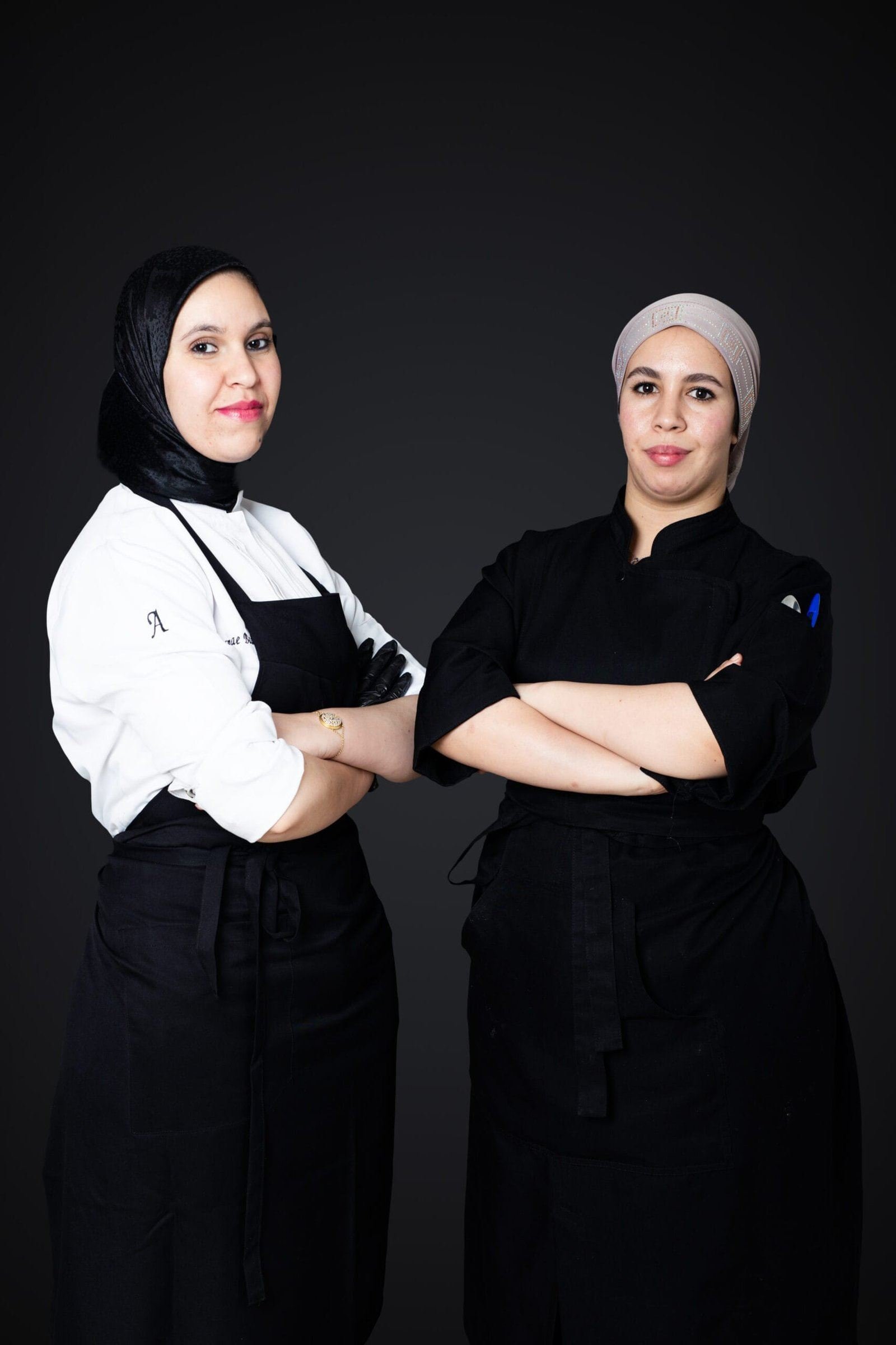 Deux membres de l'équipe de salle et de cuisine, bras croisés